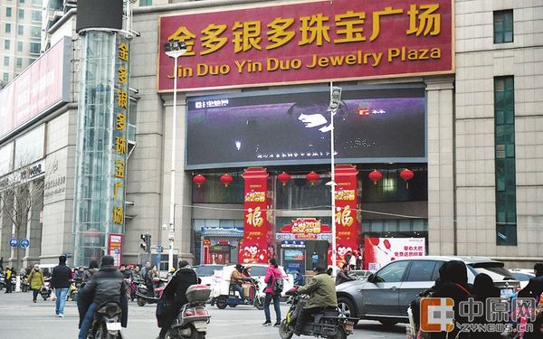 昨日下午，紫荆山路与东西大街交叉口西南角金多银多珠宝广场，过往人群驻足观看《郑州欢迎你》