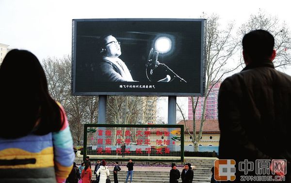 昨日下午,郑州紫荆山广场内,市民正在驻足观看大屏幕上的《郑州欢迎你》