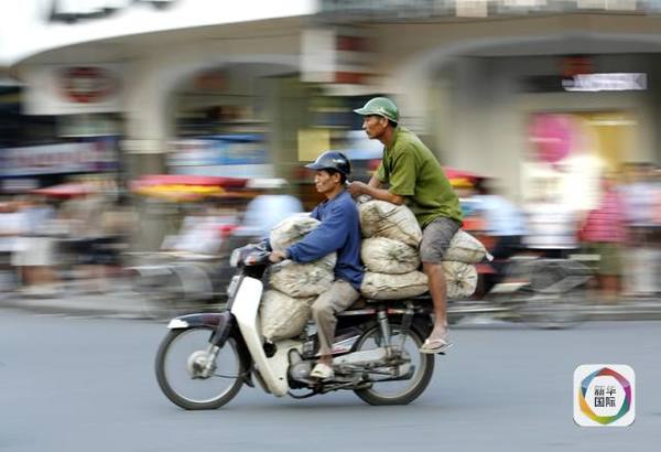 　　市民驾驶摩托车穿梭于越南首都河内街道。新华社发（胡如意摄）