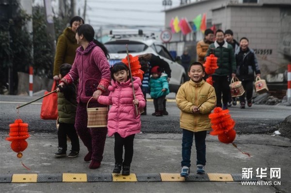1月31日,塘栖镇河西埭村的孩子们手拿红灯笼,去邻居家讨要食材制作百家饭。