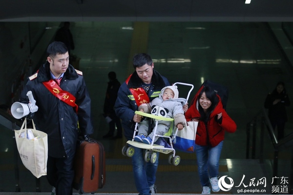 2月1日，广州车务段东莞站青年志愿者为重点旅客提携行李，帮扶旅客温暖一程。施其铭 摄