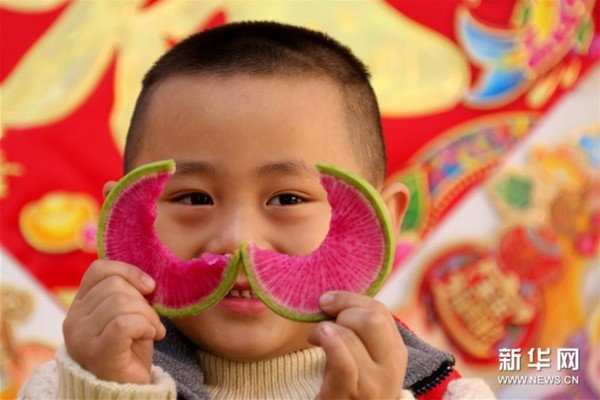 2月3日，山东省枣庄市文苑小区幼儿园的一名小朋友在吃生萝卜“咬春”。
