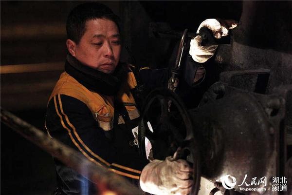 调车长余军正在对车辆进行防溜制动措施。（熊俊 摄）