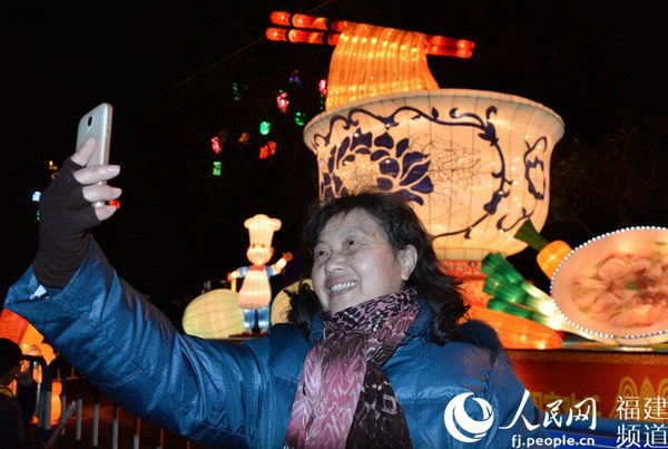 一位潮气的大妈在福州名小吃灯组前自拍。李挺摄