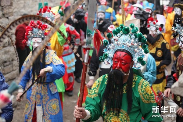 2月22日，桃林坪花脸社火队伍在村里游走。