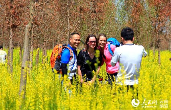 3月6日，游客在捞鱼河湿地公园油菜花中合影留念。（人民网 虎遵会 摄）