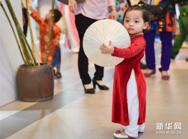 3月8日,在越南胡志明市青年文化宫举行的奥黛文化节开幕式上,一名越南儿童身着奥黛留影。