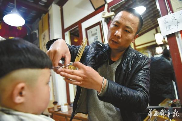 3月10日,农历二月二龙抬头,成都市工农院街的一家理发店里,师傅陈建宗为顾客剪头。