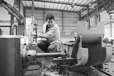 宁财建正在为推土机平衡梁镗孔。