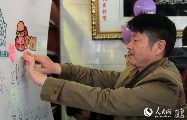 3月27日，一位爱心人士正在贴“爱心小票”。（人民网 虎遵会  摄）