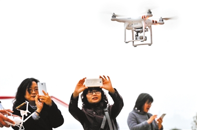玩家操控无人机，引来市民围观拍照。本报记者 甘侠义 摄