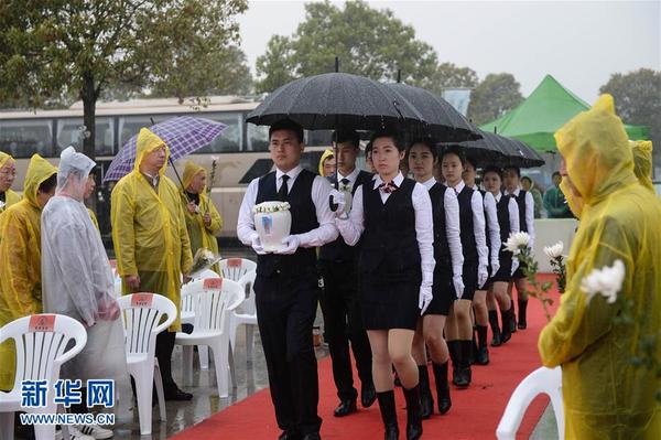 4月2日,在常州市龙城古园生态葬安葬仪式上,工作人员手捧逝者骨灰。