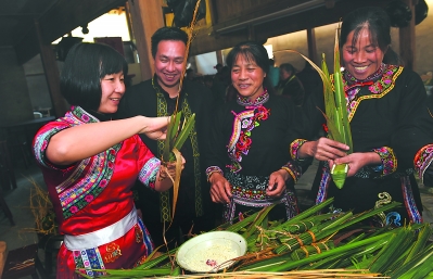 驻村干部(左一)参加包芦苇粽活动。