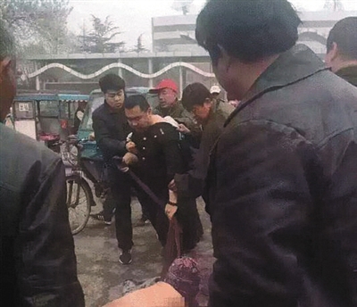 昨日，冲突中，城管扯破女摊贩的衣服。      图片来源于网络