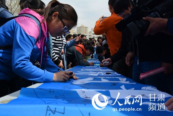 甘肃政法大学学生世界知识产权日签名活动中签名。（王文嘉 摄）