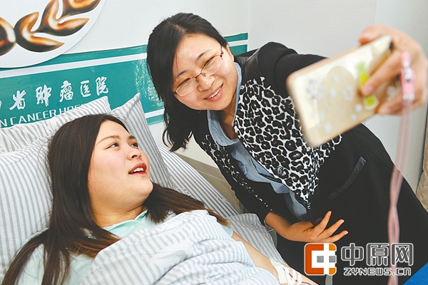 市红十字会工作人员与武佳（左）一起玩自拍