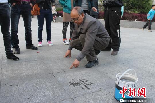 孙老在广场上写字  吸引市民观看　王喜闯　摄