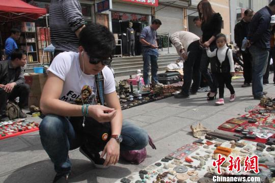 图为一90后古玩爱好者在邯郸古玩市场淘宝。　马继前　摄