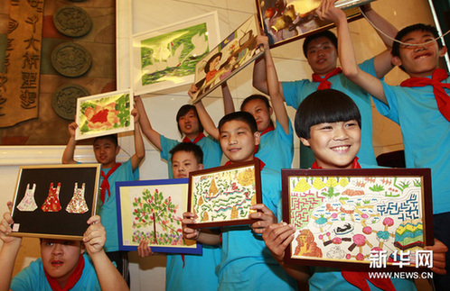 5月29日，参加义拍的青少年在义拍启动仪式上展示各自的作品。新华网图片 裴鑫 摄
