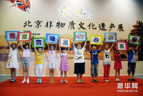 6月16日，北京市西城区金融街少年宫美术兴趣小组的孩子在展示自己动手绘制的“京味儿”邮票画。新华网图片 赵仪杰 摄