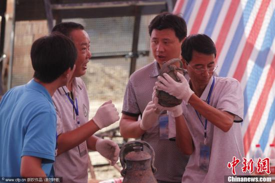 2012年7月5日，陕西宝鸡，考古人员发现在墓室北侧提取的一件青铜卣（盛酒的器具）有水晃动的声音，初步断定这晃动的液体是珍藏3000多年的西周美酒。赵航 摄 图片来源：CFP视觉中国