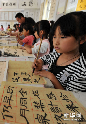 10月15日,东乡县小璜镇中心小学的何志林(右)等在上书法课.