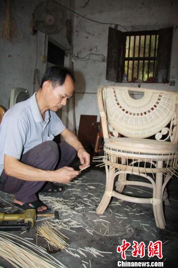 民间艺人正在编织藤椅。　蔡欣欣　摄