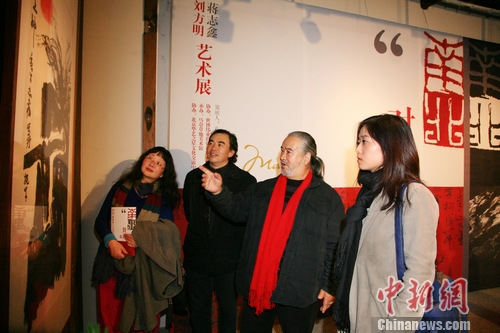 在画展上，蒋志鑫（左三）、刘方明（左二）与观众交流。