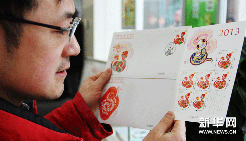 1月5日，苏州一名集邮爱好者在展示刚购买到的《癸巳年》生肖“蛇”邮票和首日封。