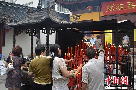 市民及游客在神仙庙内点香烛祈福。　王思哲　摄