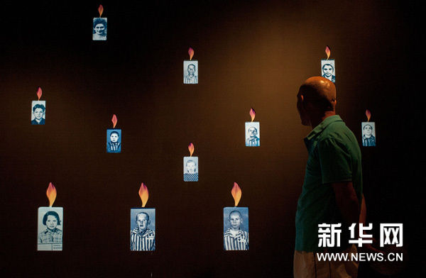 7月7日，一名观众在蜡烛墙前驻足。新华网图片 张宇 摄