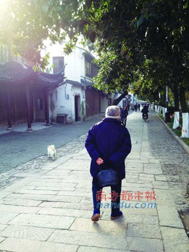 清晨，苏州老人听着收音机，走在平江路上。