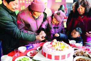 寿宴现场，两位老人在切生日蛋糕。