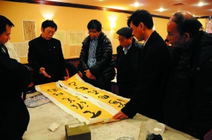 　　张旭光给华人书法家点评作品。