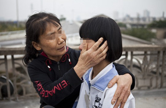 2013年10月16日，长沙四方坪胜利村，妈妈心疼地为女儿湘湘（化名）擦眼泪。