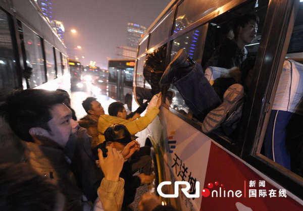 组图:北京公交车门路堵死 乘客爬窗上车