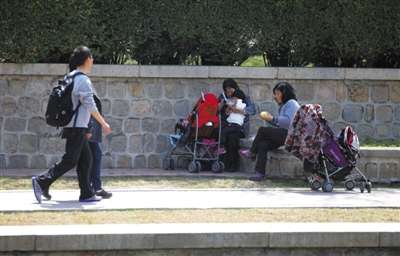 4月12日，元大都公园，游客们坐在花坛边休息。