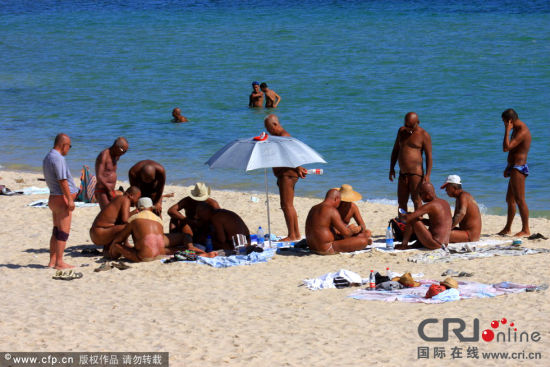 　　海滩上，个别游客偷偷褪去短裤。图片来源：东海/CFP