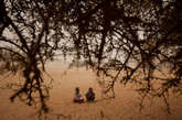 当地时间2012年4月19日，乍得草原荒漠地带的Tchyllah村庄，两个男孩正坐在沙地上。

