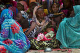 当地时间2012年4月18日，妇女们耐心等待人们给她们的孩子检查是否营养不良。

