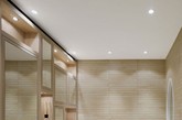 同时，一组对称的白漆橡木浴室橱柜沿着房间的长度延伸，给人以空间立体有序的舒适感。浴室的镜像门和多种照明装置的合理的安排，它散发出浓郁的丰盈感，并提供了充足的储物空间。