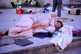 7月25日凌晨，大批求职民工睡在义乌市劳动力市场前的空旷地上。

