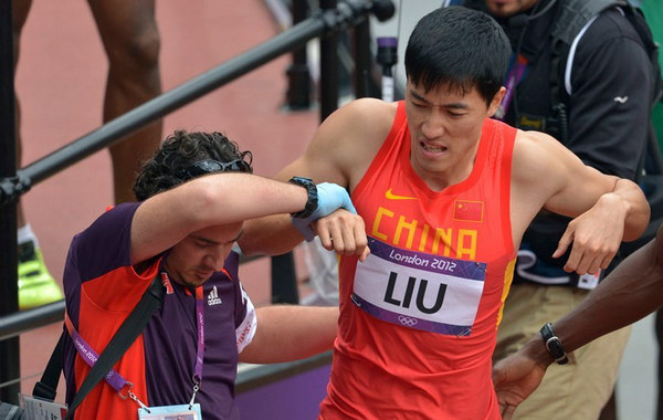 刘翔摔倒退赛，单腿继续跳完全程，最后坐上轮椅离场。