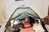 22岁的沙特姑娘舒服地坐在吉达野营帐篷里，打开她的笔记本电脑。尽管在公共场所，阿拉伯女性被要求遮盖全身，但她们在家时，通常身穿着西式服装，放松自己。
