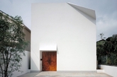 日本建筑师桥本夕纪夫（Yukio Hashimoto）设计的F-House是一座双层住宅，位于以艺伎文化闻名的京都祗园地区。极简的设计风格，融入了日本传统的折纸技艺，在屋角和门檐上的轻盈的一折，赋予了建筑独特的灵性。建筑是极简的盒子外形，立面如同一张干净的白纸。折叠细节的采用，改变了建筑原本容易呈现出来的封闭性和沉重感。正面的木门采用马栗木制作，在色彩和质感上与墙壁形成反差。建筑外墙不开设窗户，像许多日本建筑一样是通过一个露天的中庭实现采光。这样的中庭，即在室内，又在室外，能感知时间光暗、四季雨雪的变化。（实习编辑：胡嘉怡）