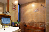 以古朴的木质浴桶来替代浴缸，小小的卫浴空间中就此显出一种古朴的感觉，浅色正方瓷砖在暖色灯光照射下，让整间卫生间的温馨舒适感倍增。