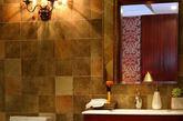 复古色调的彩色瓷砖与大理石地面拼贴出这一具有复古感觉的卫浴空间，特别是墙面上的壁灯为这个卫生间添加了不少复古氛围，简约的整理台也显出一种异域气质。