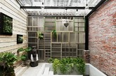 这是由台湾好室设计／House Design 打造的作品，改造的对象是一幢屋龄超过50年的狭长老屋。老房子在一楼与二楼间有个影响动线的夹层，但拆除并非唯一的办法 ，设计师在这里就选择了推开夹层的封闭墙面，从而让底层、夹层与露台间串联起了一个新的关联，并形成一个层层递进的光与景。原来弃置不用的露台被重新定义为阅读区 ，在旧物、绿植、旧有的窗框环绕下，营造一个安静的阅读氛围，而浴室也就大方的设置在露台上方的过道间，坦然的迎向阳光。（实习编辑：谭婉仪）