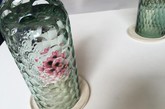 OP-vase 是由土耳其设计师 Bilge Nur Saltik 构思创建的一系列花瓶，通过视觉扭曲、万花筒原理，设计师使一朵花仿佛幻化出万千抽象花朵 ，遍布花瓶瓶罩上的整个球面空间。整个系列由三个不同尺寸的花瓶组成，每一个都用玻璃手工吹制而成，并有各自独特的图案和切口，或蓝或绿、或深或浅的颜色又给鲜花增色不少 。当观察者转动并改变角度时，玻璃罩上的鲜花也随之变化形式，万千归一、一化万千。（实习编辑：谭婉仪）