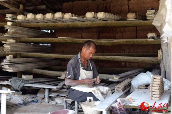 德化月记窑工人正在制作茶壶把。（人民网记者翁奇羽摄）